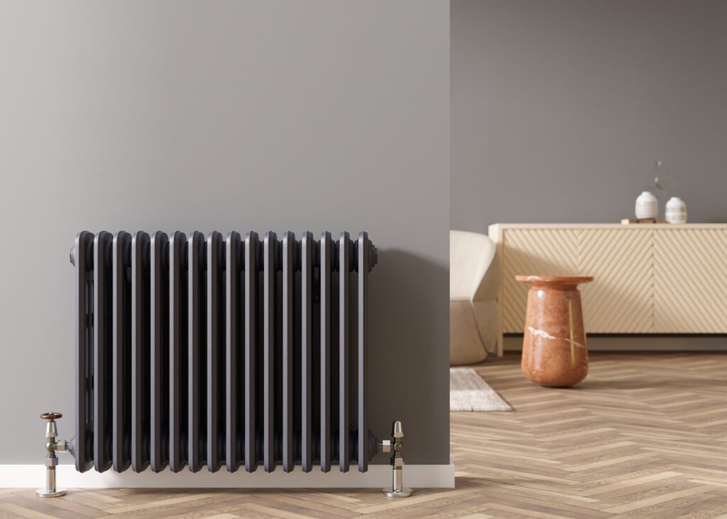 Heating radiator on gray wall in modern room. Home interior. Central heating system.