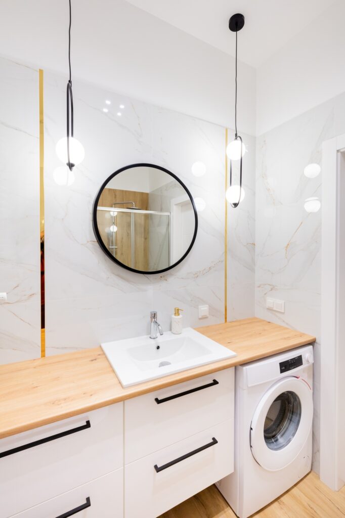 Stylish bathroom with round mirror and marble wall