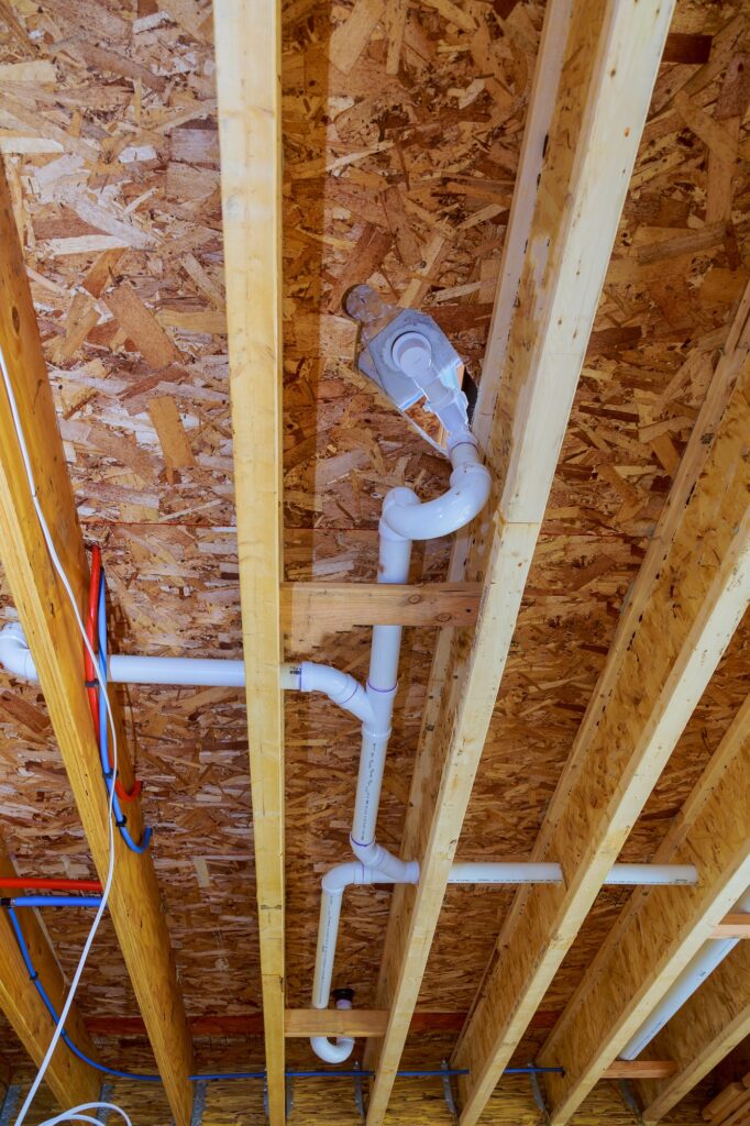 White PVS pipeline under white ceiling in the new house construction industry pipeline for drainage